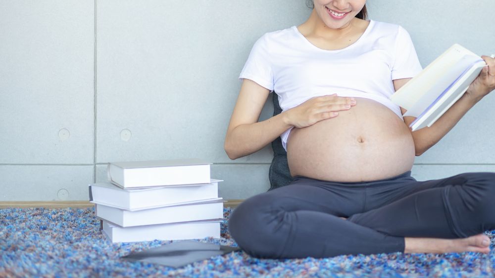 本を読んでいる妊娠中の女性