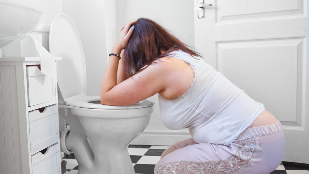 トイレで嘔吐する女性